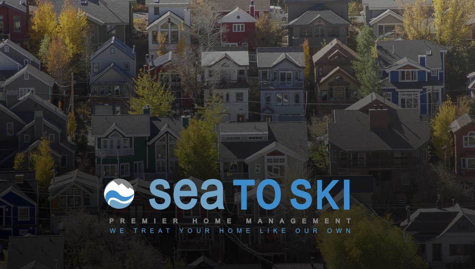 A neighborhood of colorful houses and trees with Sea to Ski logo.