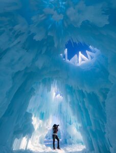 woman taking photograph in ice cave