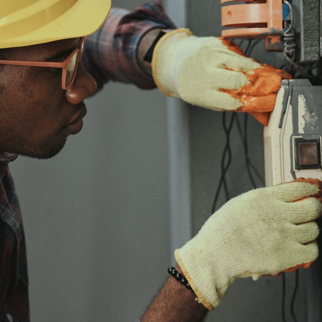 Man in hard hat work with equipment on a wall