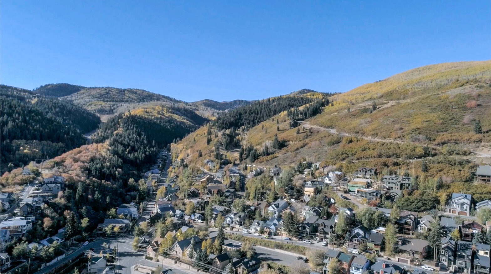 HOA Reserve Study | aerial view of a town surrounded with mountains covered in trees.